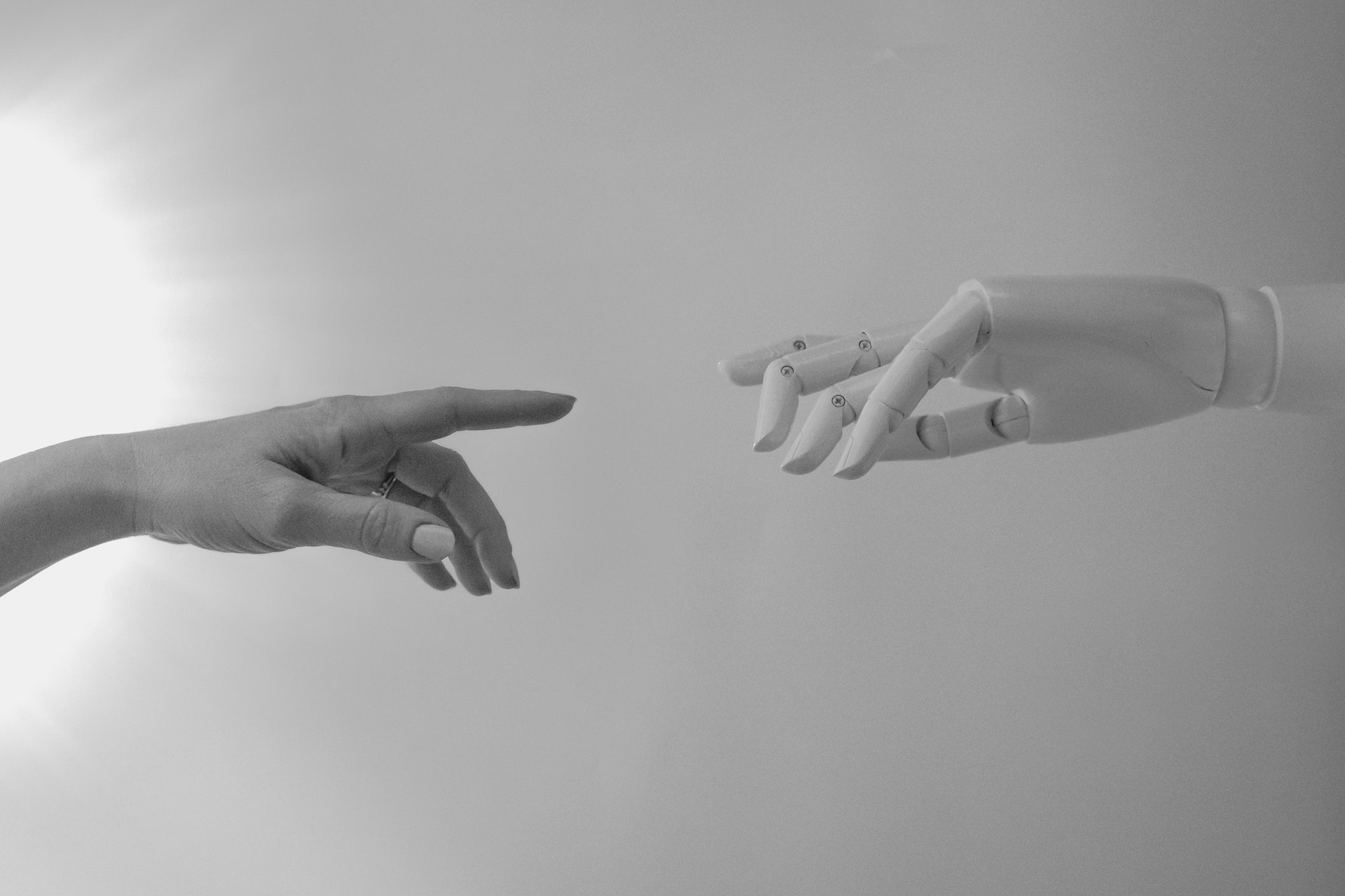 human hand and robot hand about to touch