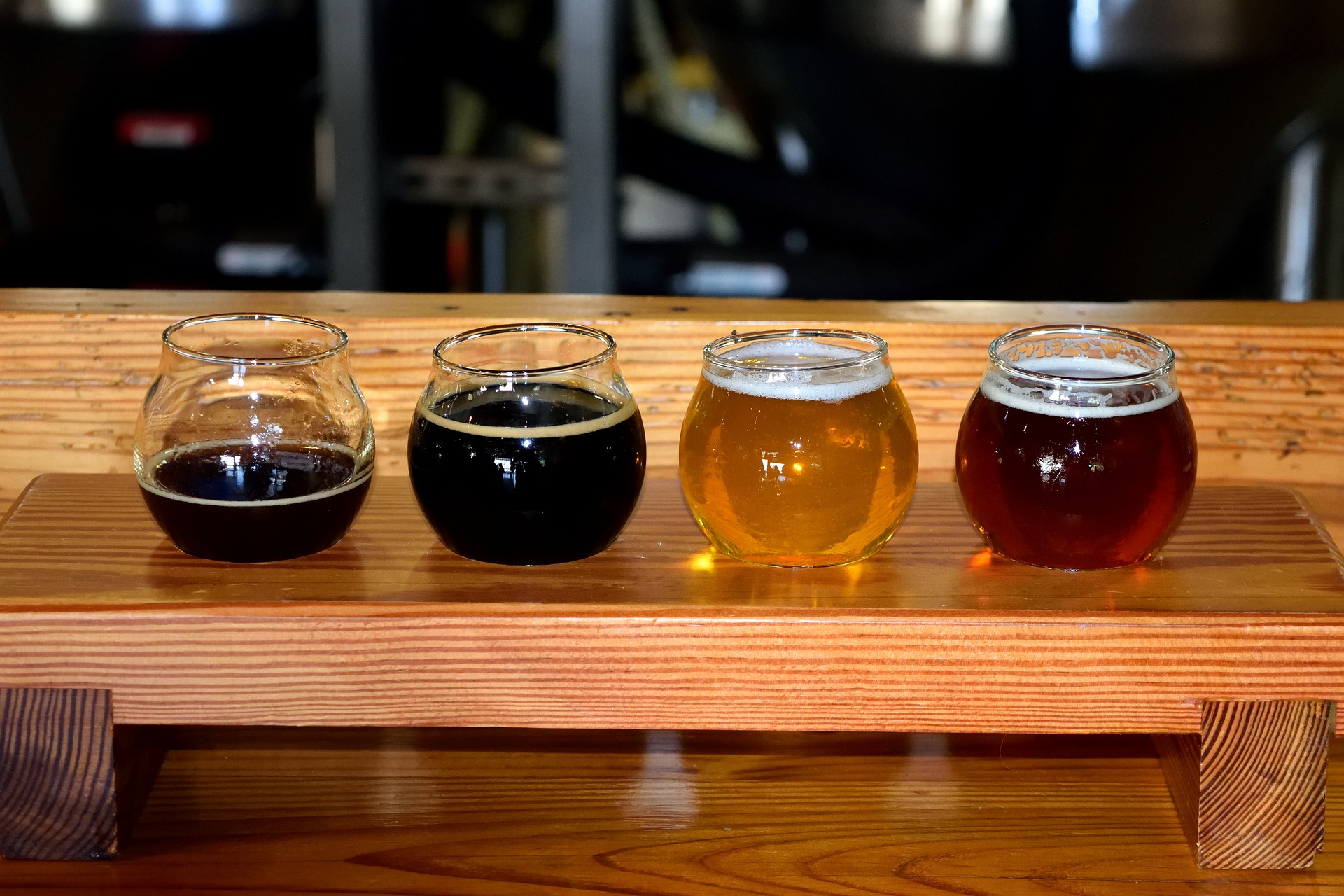 beer tasting with four different beers presented on a wooden paddle