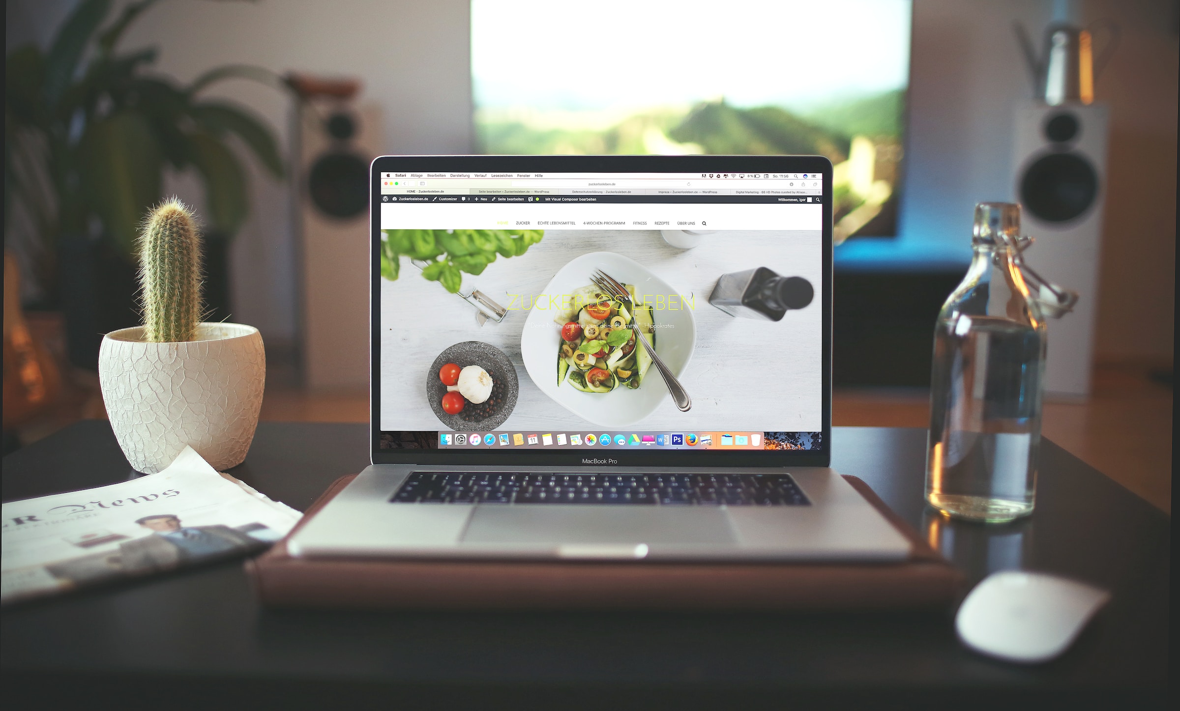 restaurant website page shown on laptop sitting on table with cactus and lamp